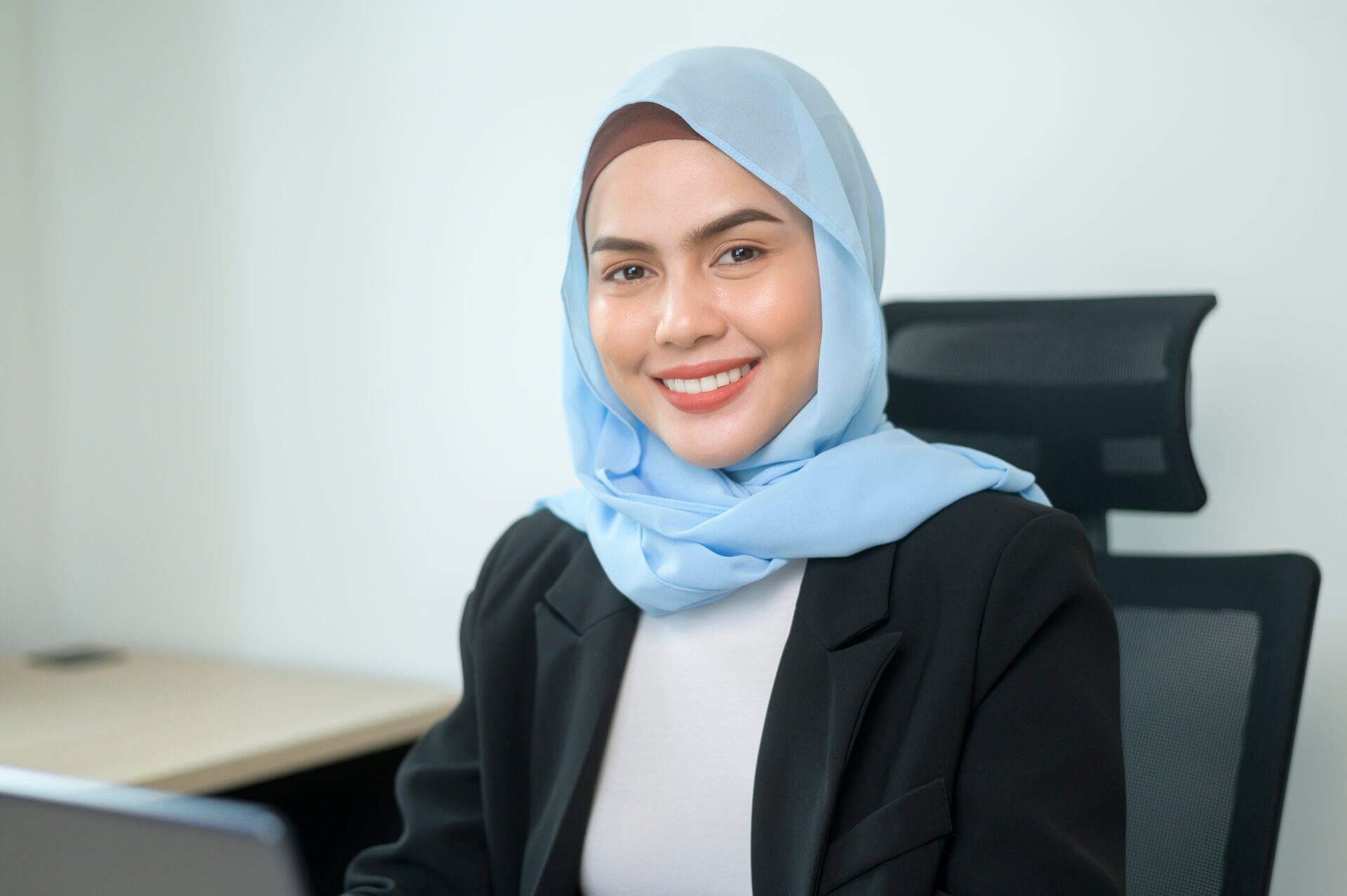 young muslim business woman working laptop with documents modern office